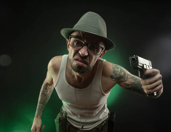 Un sportif avec un tatouage pose avec un pistolet — Photo