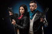 Egy lány és egy fickó egy bőrdzsekiben fegyverrel.