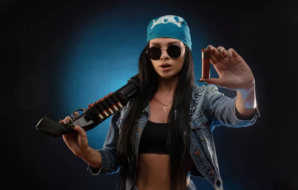 Meisje in een spijkerjasje met een geweer — Stockfoto