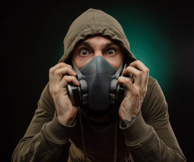 Gri arka planda gaz maskeli bir adamın fotoğrafı.