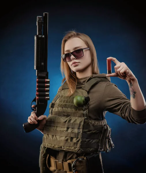 La chica en mono militar airsoft posando con una pistola en sus manos sobre un fondo oscuro — Foto de Stock
