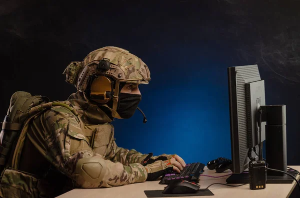 Militar en uniforme sentado en una computadora lleva a cabo la guerra cibernética —  Fotos de Stock