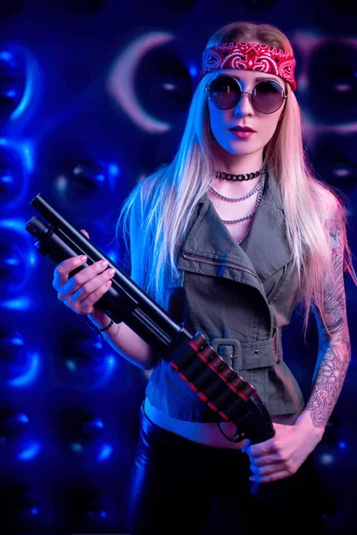 Una chica que parece un hippie con una escopeta en neón — Foto de Stock