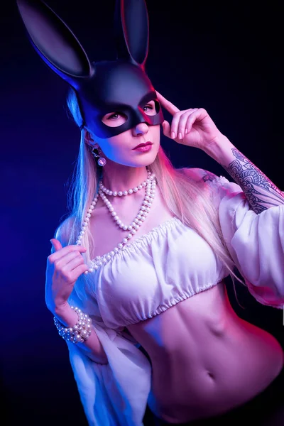 Sexy meisje in een konijn masker in neon licht — Stockfoto