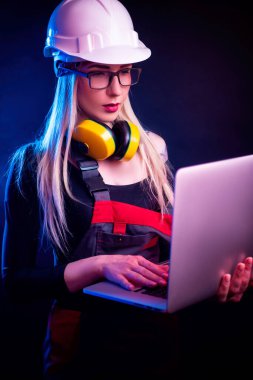Gözlüklü, dizüstü bilgisayarı olan seksi bir kadın mimar. neon ışıkta