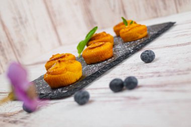 Böğürtlenli kek, pudra şekeri ve taze meyveli.