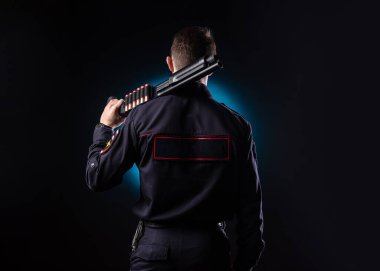 Silahlı, polis üniformalı yakışıklı bir adam.
