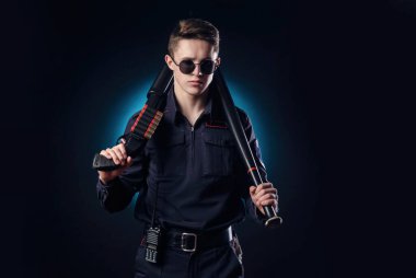 Silahlı ve beysbol sopalı polis üniformalı yakışıklı bir adam.