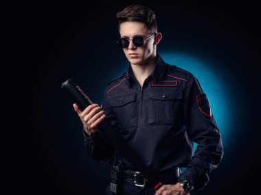 Polis üniformalı yakışıklı adam beyzbol sopasıyla.