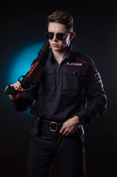 Um tipo bonito de uniforme de polícia com uma arma. tradução para inglês "Police " — Fotografia de Stock