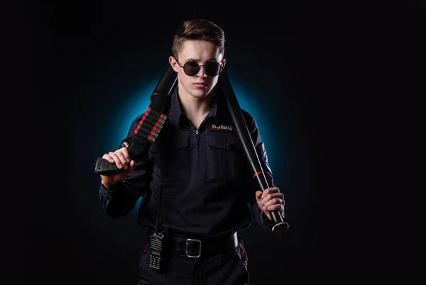 Gutaussehender Typ in Polizeiuniform mit Waffe und Baseballschläger. englische Übersetzung "Police" — Stockfoto