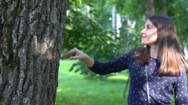 Frau lächelt und berührt den Baum — Stockvideo