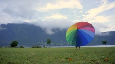 The boy rotates the umbrella on the Bratan lake
