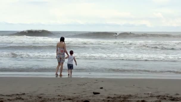 Мать и ее сын на пляже — стоковое видео