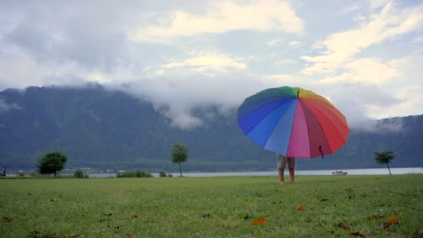 Liten pojke roterar paraply vid sjön Bratan — Stockvideo