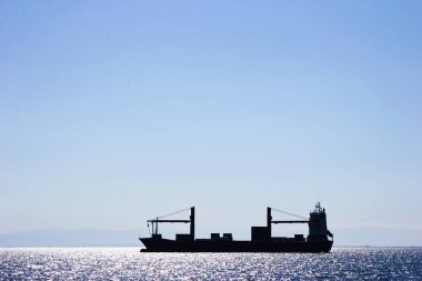 Deniz günbatımı bir arka plan üzerinde gemi silueti