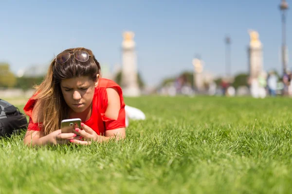 Frau in Paris checkt ihr Smartphone — Stockfoto