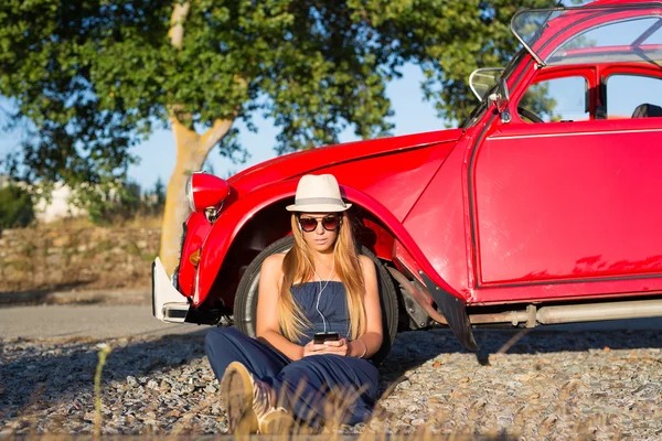 Jonge vrouw rusten op auto — Stockfoto