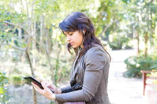 公園でタブレット コンピューターを持つ女性 — ストック写真