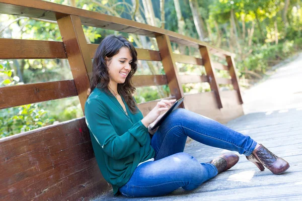 Femme avec un ordinateur tablette au parc — Photo