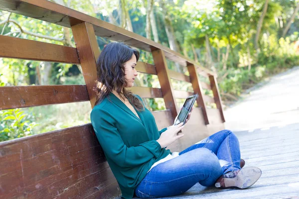 公園でタブレット コンピューターを持つ女性 — ストック写真