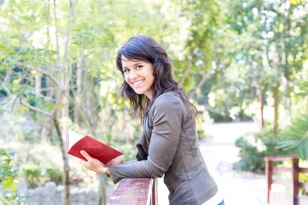 Kvinna läser en bok på park — Stockfoto