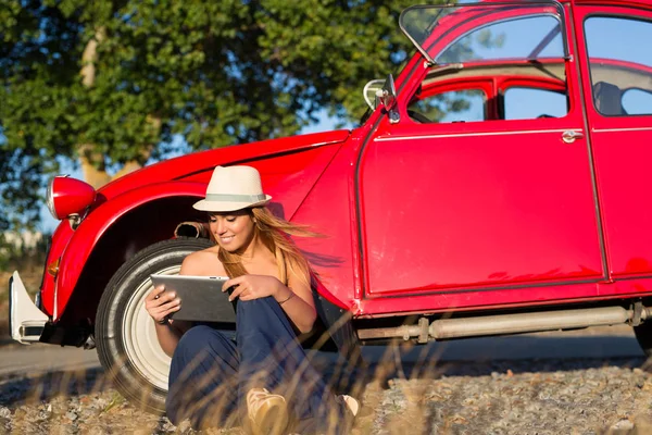 Jonge vrouw rusten op auto — Stockfoto