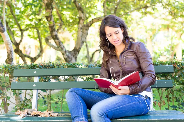 Kitap okuyan genç bir kadın. — Stok fotoğraf