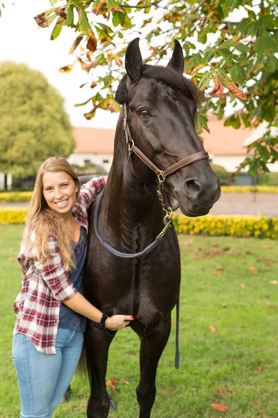 Joven hermosa mujer con un caballo — Foto de Stock