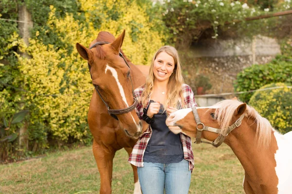 Jovem mulher bonita com cavalos — Fotografia de Stock