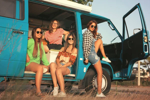 Young hippie women traveling by car
