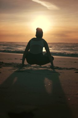 Plaj, sağlıklı yaşam ve beden ve ruhsal gelişimi arasında doğal denge kavramı, yoga pratik yapıyor sportif genç kadın silüeti