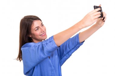 Beyaz arka plan üzerinde kendi kendine portre fotoğrafçılığı akıllı telefon aracılığıyla alarak mutlu genç kadın.