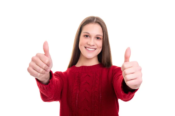 美丽的年轻女子在温暖的针织红色毛衣显示竖起大拇指 而在白色背景上摆出孤立 — 图库照片