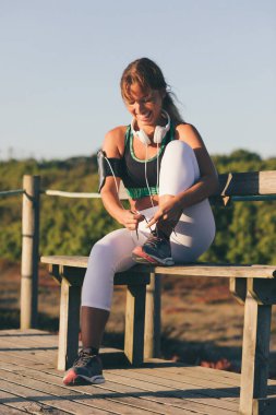 Genç ve güzel bir kadın gün doğumunda sahilde egzersiz yapıyor. 