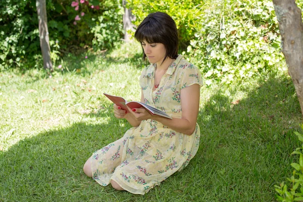 Bella giovane donna lettura libro al parco — Foto Stock