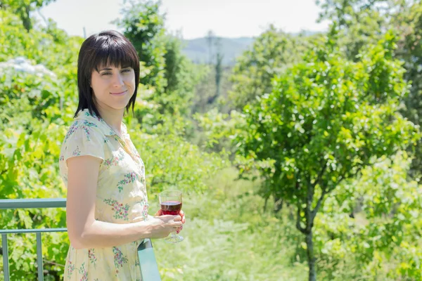 Жінка п'є червоне вино в винограднику, надворі — стокове фото