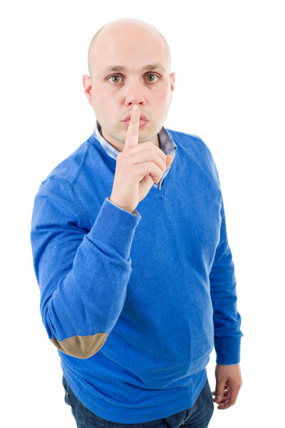 portrait of a young bald man making a shushing gesture with his finger, isolated