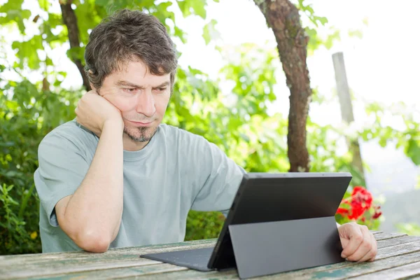 Hombre casual que trabaja con una tableta PC, al aire libre — Foto de Stock