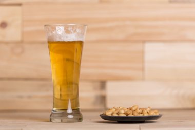 Ahşap masa, hareketsiz yaşam tarzı üzerinde kavrulmuş fıstık ile soğuk bira