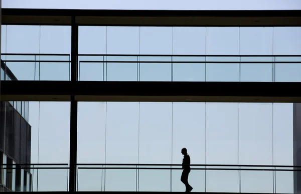 Vista silhueta de um jovem empresário num moderno edifício de escritórios interior — Fotografia de Stock