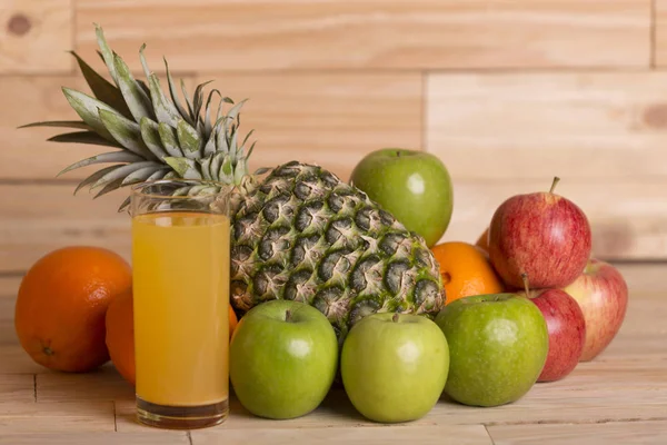 Mängd olika frukter och orange juice på ett träbord, studio bild — Stockfoto