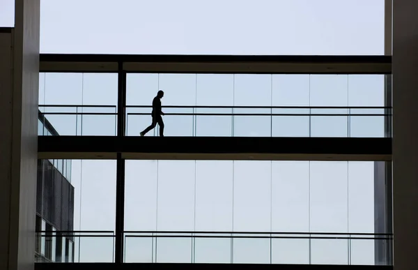 Silhouettenaufnahme eines jungen Geschäftsmannes in einem modernen Bürogebäude — Stockfoto