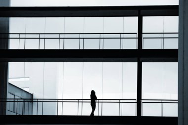 Modern ofis binası içinde genç işkadını görünümünü siluet