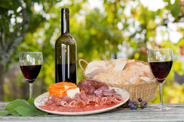 Country life setting with wine, fruits, cheese and meat. Outdoor — Stock Photo, Image