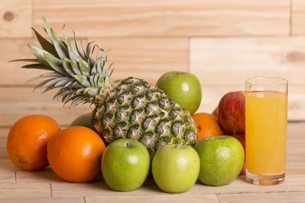 Mängd olika frukter och orange juice på ett träbord, studio bild — Stockfoto