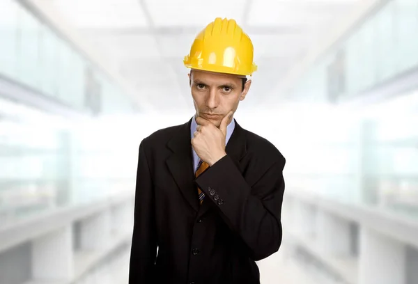 Un ingénieur au chapeau jaune réfléchissant au bureau — Photo