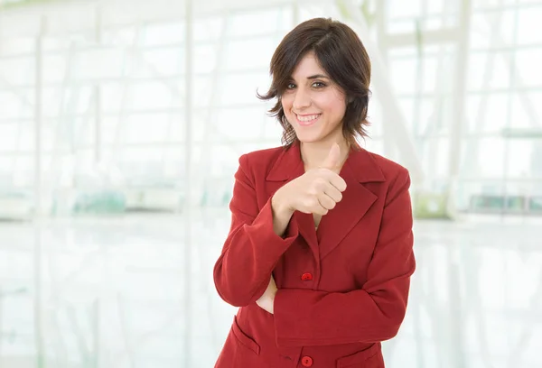 Молодая деловая женщина собирается большой палец вверх, в офисе — стоковое фото