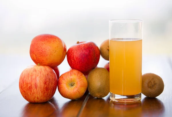 Früchte und Saft auf einem Holztisch, im Freien — Stockfoto