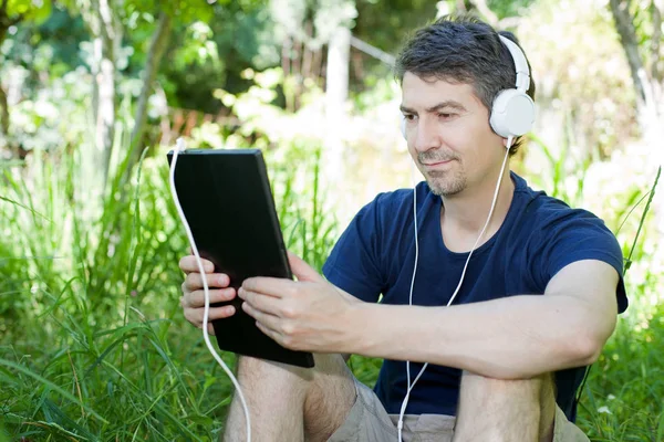 Casual uomo che lavora con un tablet pc, all'aperto — Foto Stock